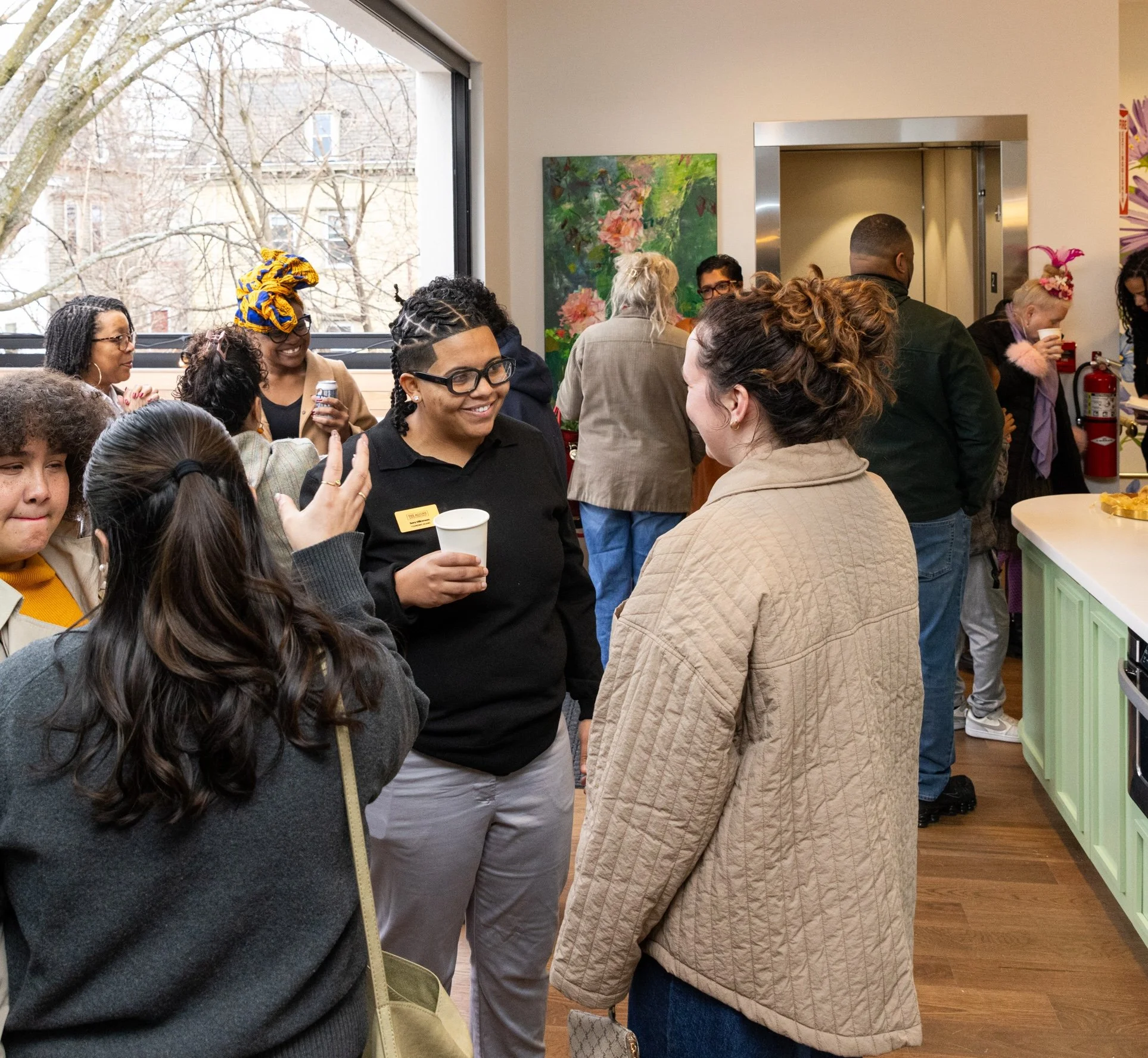 A lively open house gathering of women and gender expansive community members gathering at The Alcove, a gender inclusive community space in Providence, RI