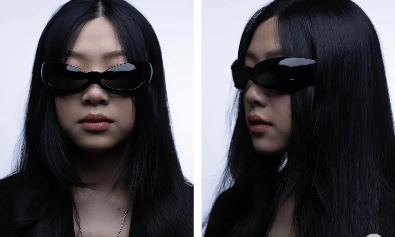 A woman with long black hair wearing large black sunglasses and a black top, photographed from the front and side against a plain white background.