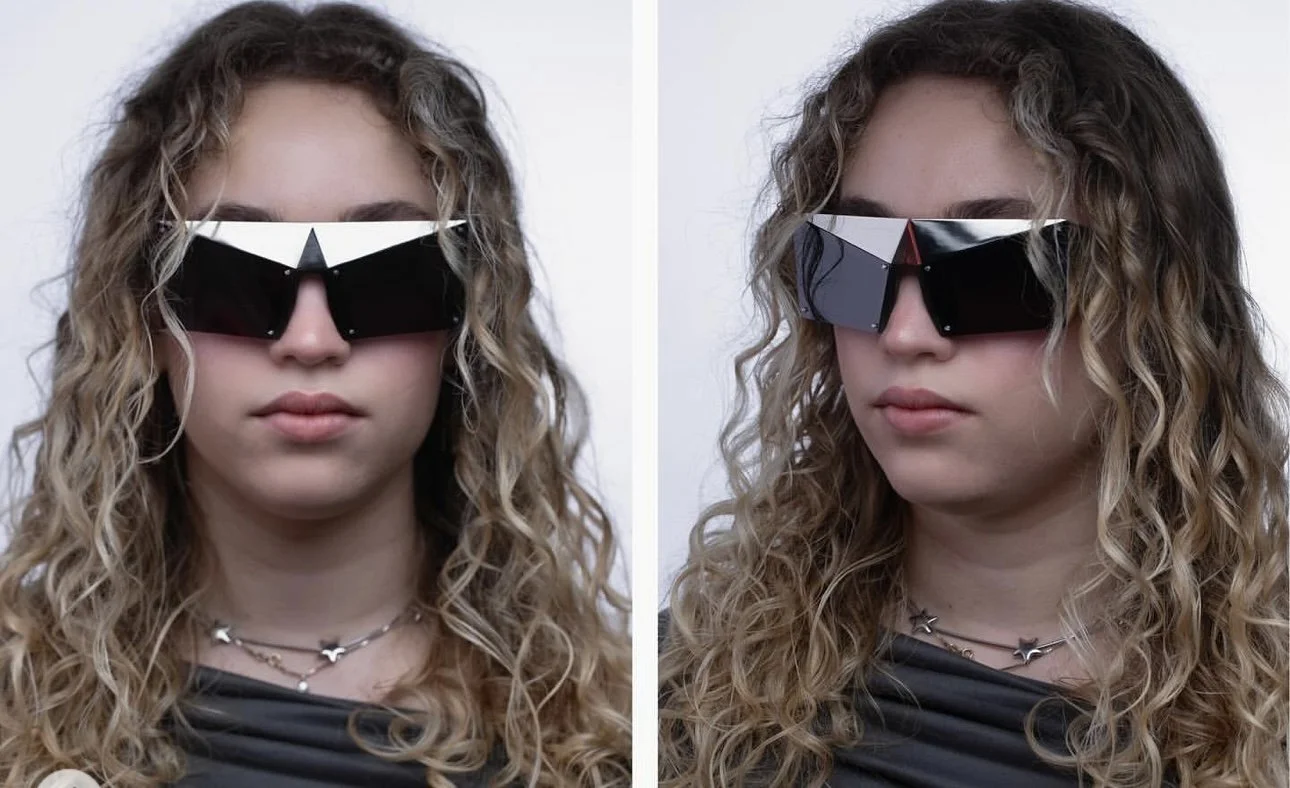 A woman with curly, blonde hair is wearing oversized, geometric black sunglasses and layered necklaces, in two side-by-side photos with different facial expressions.