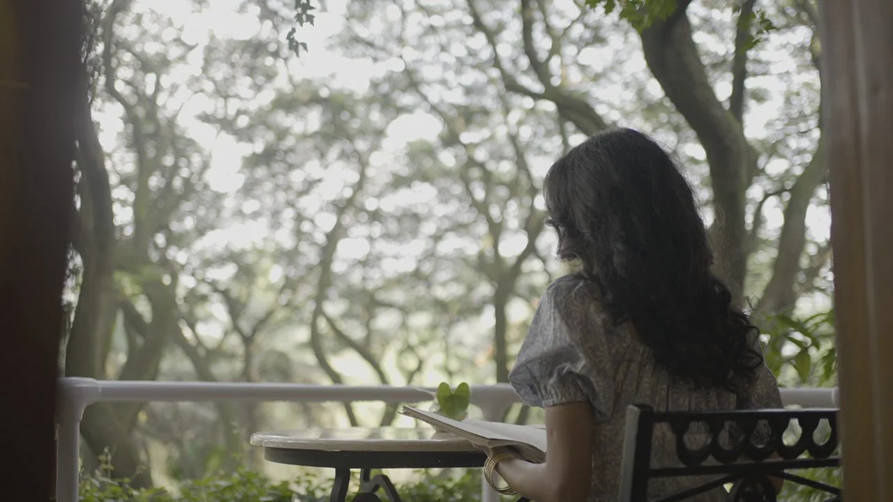 view of a woman seeking clarity and self-respect through meditation and reading, framed by a serene natural landscape that symbolizes inner growth.