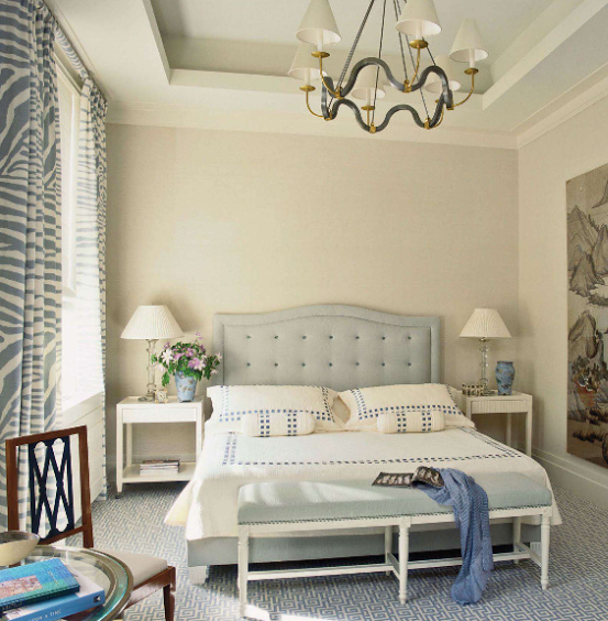 Bedroom with a bed, two nightstands with lamps, and curtains by the window.