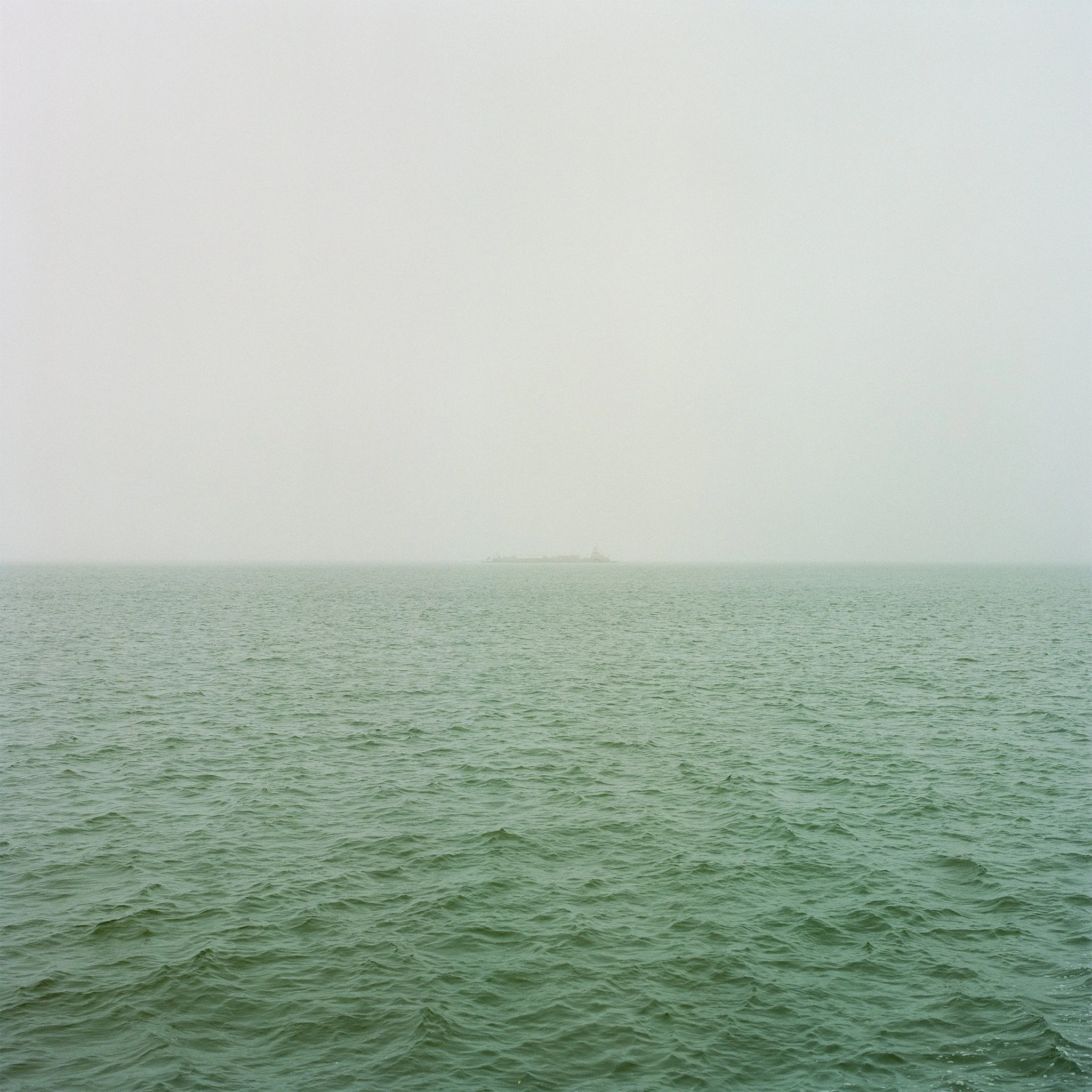 Overcast ocean with a ship in the distance.