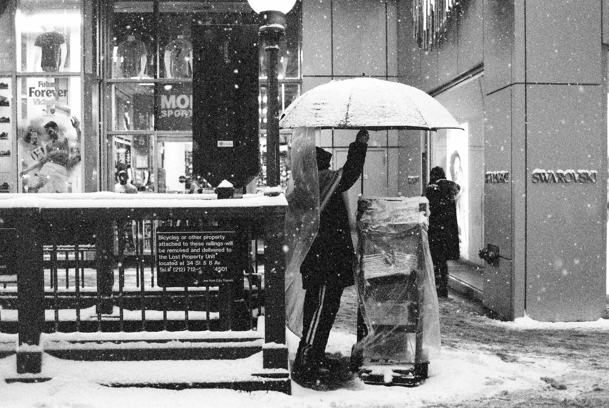 NEW_YORK_FILM_PHOTOGRAPHY_SNOW_BLIZZARD_PUTTING_UP_UMBRELLA_NEWSPAPER.jpg