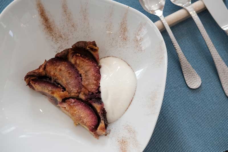 Slice of fried plantain served with a dollop of white sauce or cream on a white plate