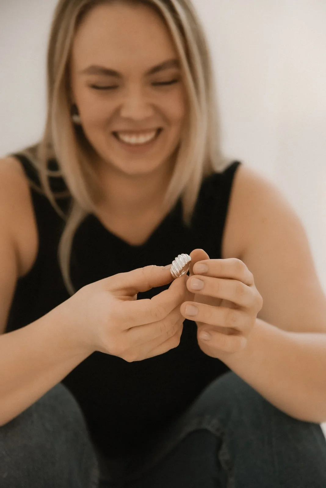 Tuotekuva, jossa naisyrittäjä pitelee suunnittelmaansa sormusta.