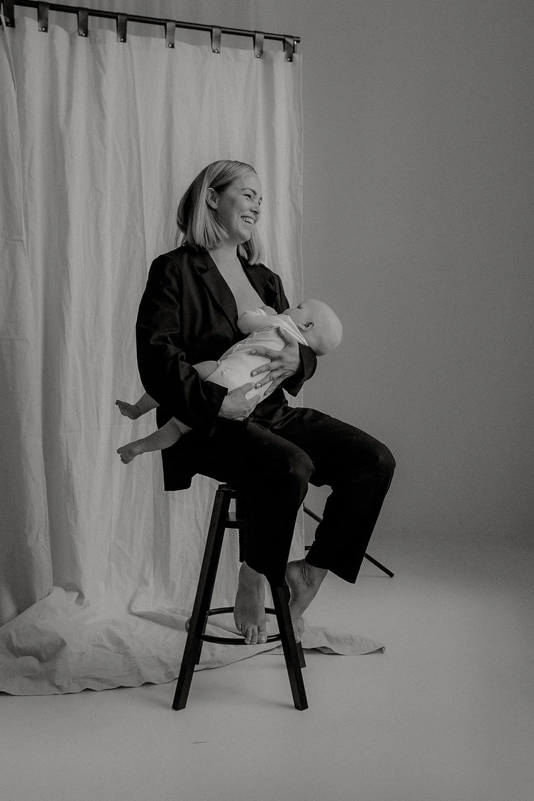 Äiti istuu tuolilla ja imettää lastaan. Kuvattu Heidi Väisäsen kauniissa valokuvausstudiossa.