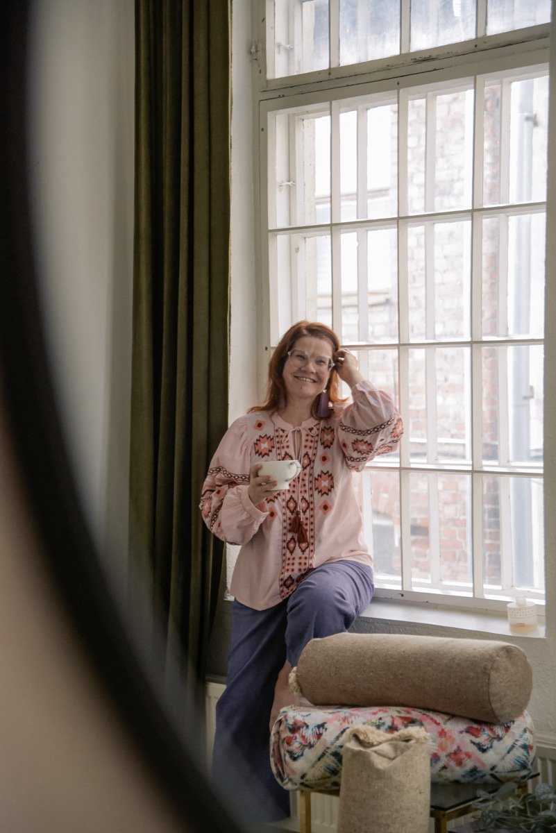 Henkilökuva yrittäjä Virve Taljavirtasta istumassa ikkunalaudalla. Kuvannut brändikuvaaja Heidi Väisänen.
