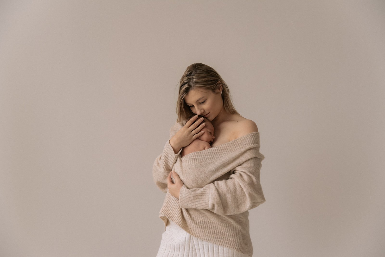 Vanhempi pitää vastasyntynyttä sylissään. Vastasyntyneen kuvaus Helsinki.