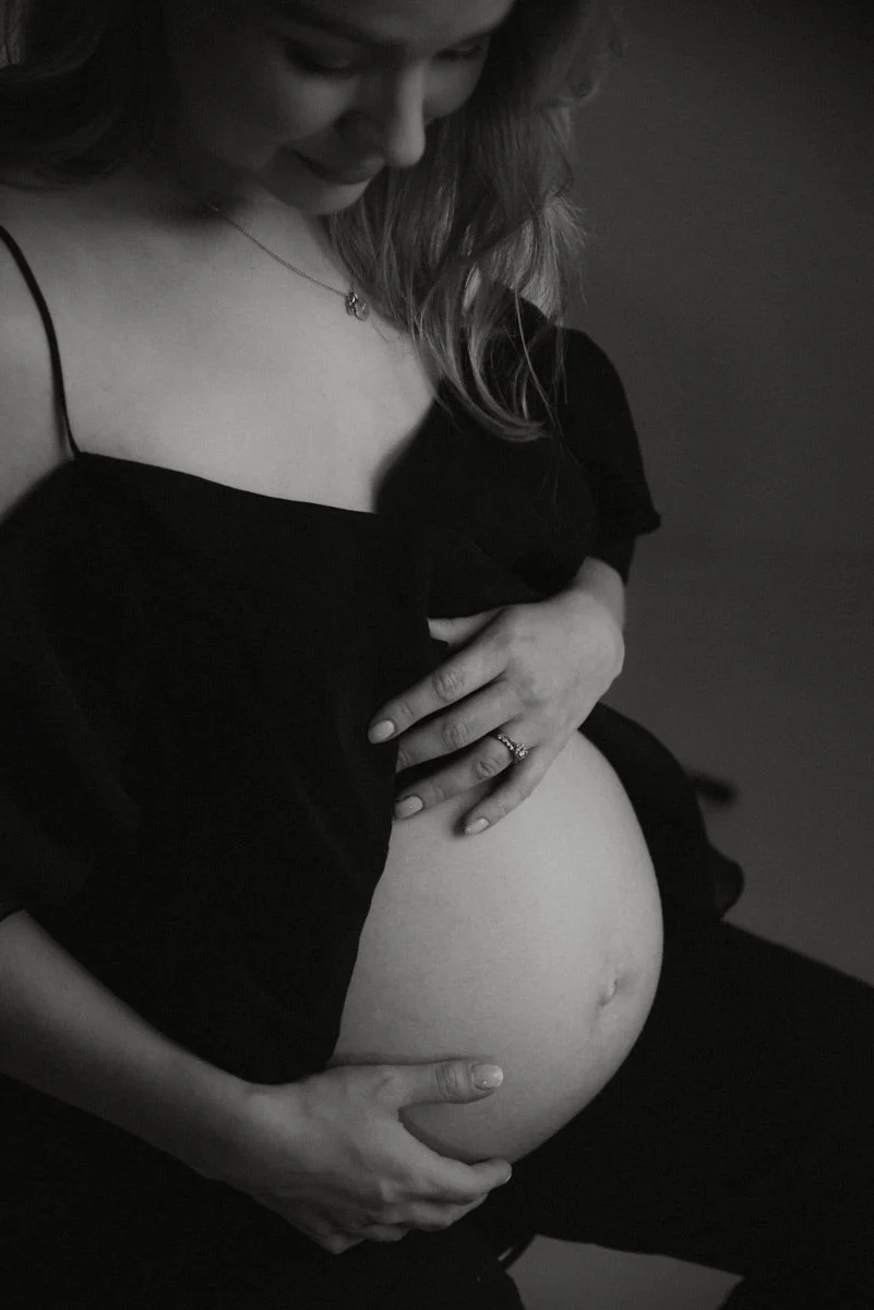 Odotusajankuvaus, odottava äiti pitelee vatsaansa valoisalla studiolla.