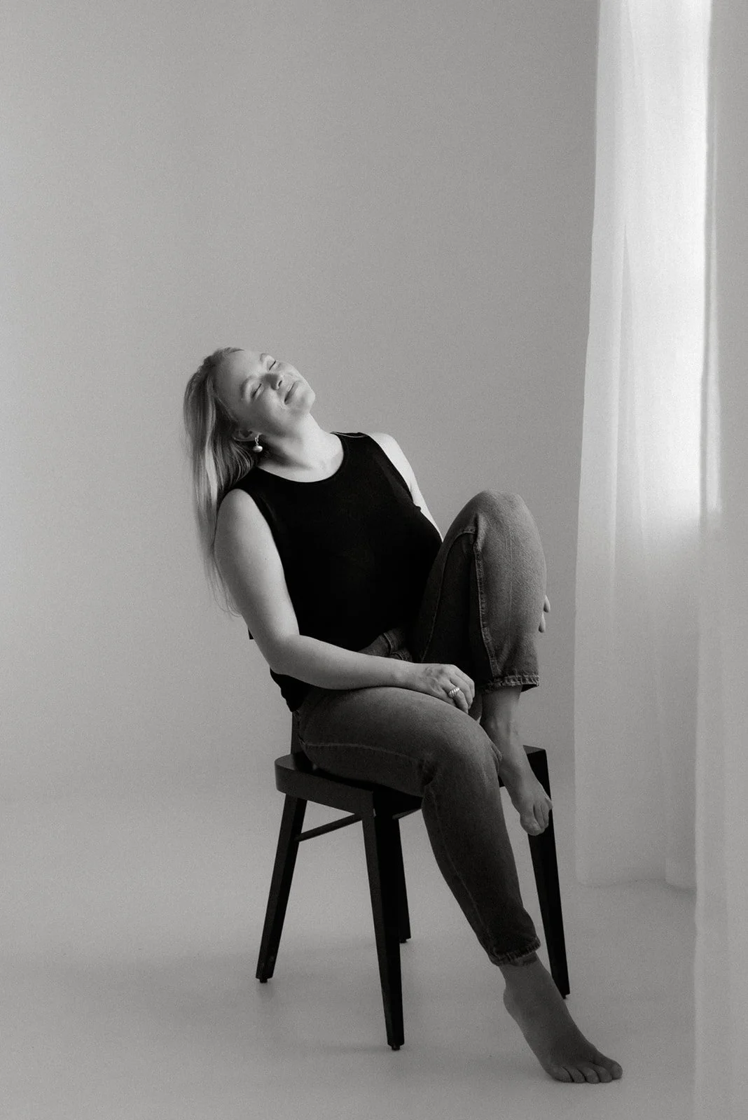 Jemilia Designin yrittäjä istuu rennosti tuolilla studiolla Keravalla.