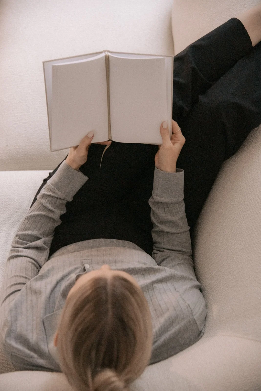 Heartiven yrittäjä Terhi makaa sohvalla muistikirjan kanssa brändikuvauksessa studiolla.