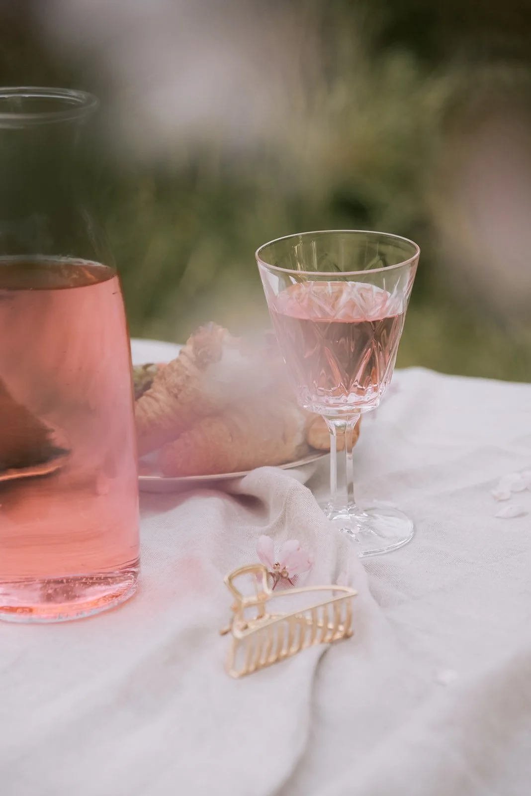 Tuotekuva lasista ja tarjoiluista piknik-viltin päällä.