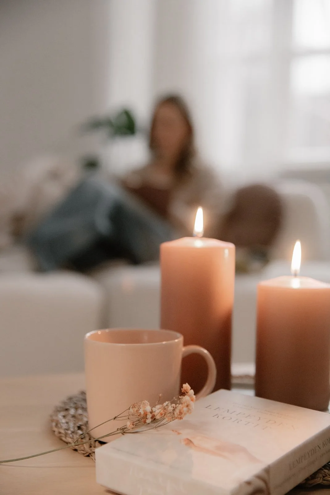 Vaumiin brändikuvassa kahvikuppi ja tunnelmalliset kynttilät.