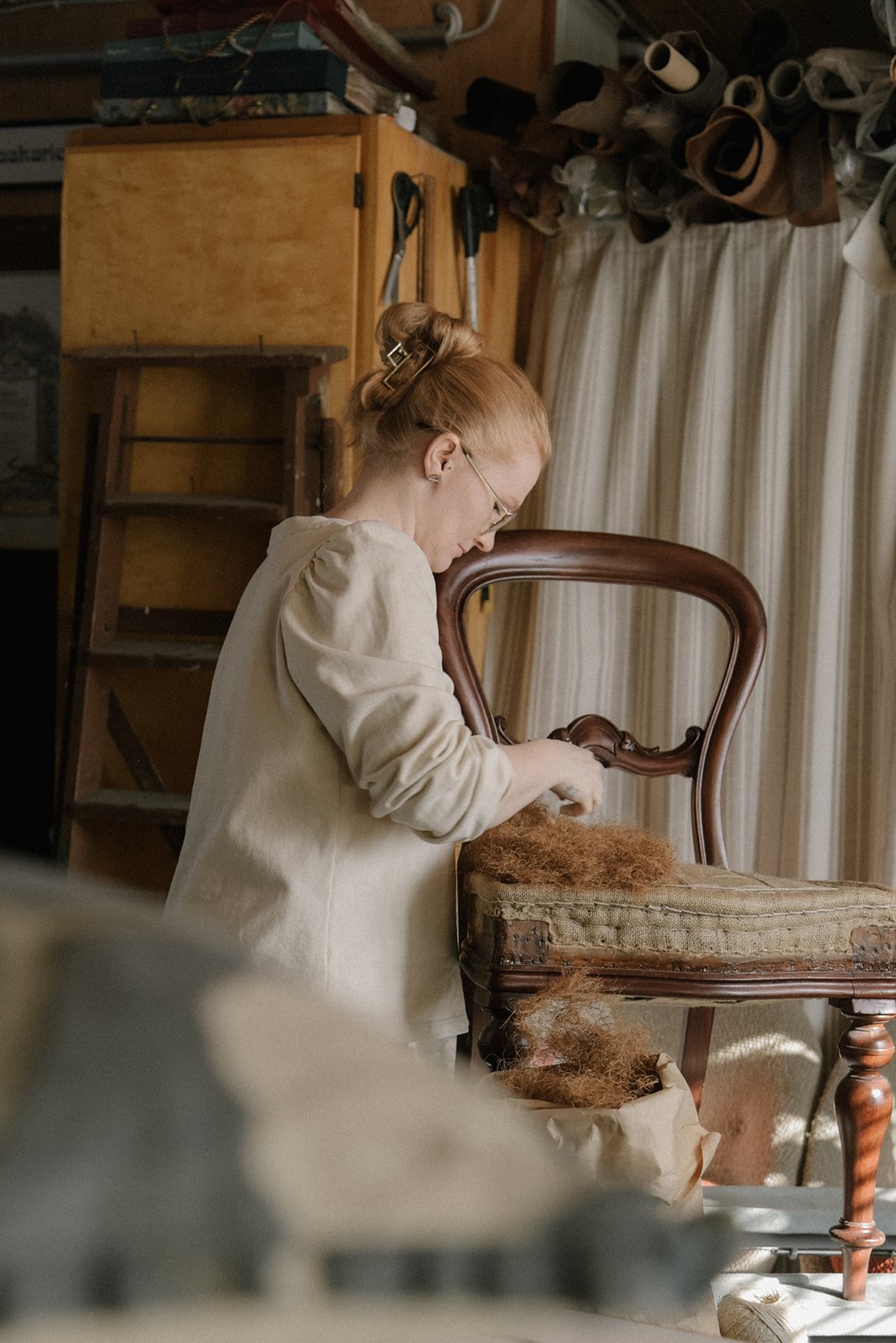 Verhoiluliike Eklundin yrityskuvaus, yrittäjä Ida Eklund työssään verhoomolla.