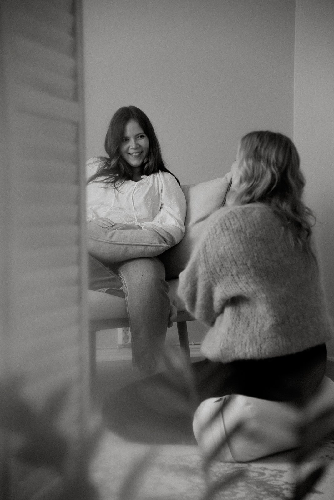 Yrityskuvaus liiketilassa. Doula keskustelee asiakkaansa kanssa mustavalkokuvassa.