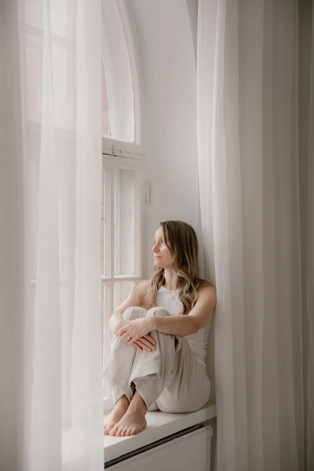 Vaumiin brändikuvaus, Vaumiin yrittäjä Miia istuu ikkunalaudalla harmonisessa kuvausstudiossa Saviolla Keravalla.