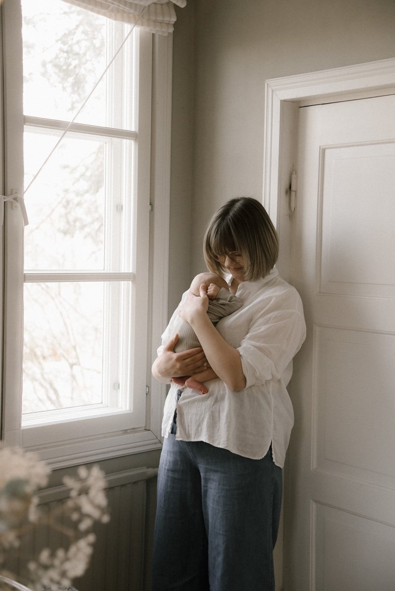 Äiti kotonaan vastasyntyneen kanssa. Vauvakuvaus Helsinki.