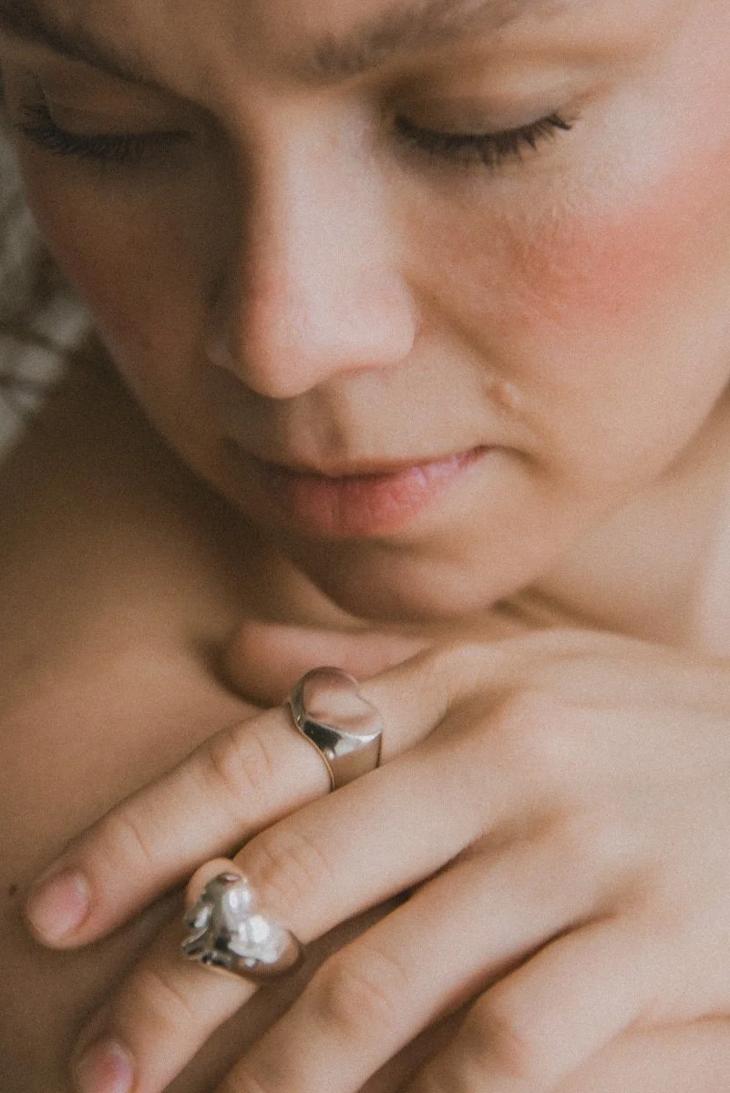 Tuotekuva, jossa yrittäjällä sormissaan suunnittelmansa korut.