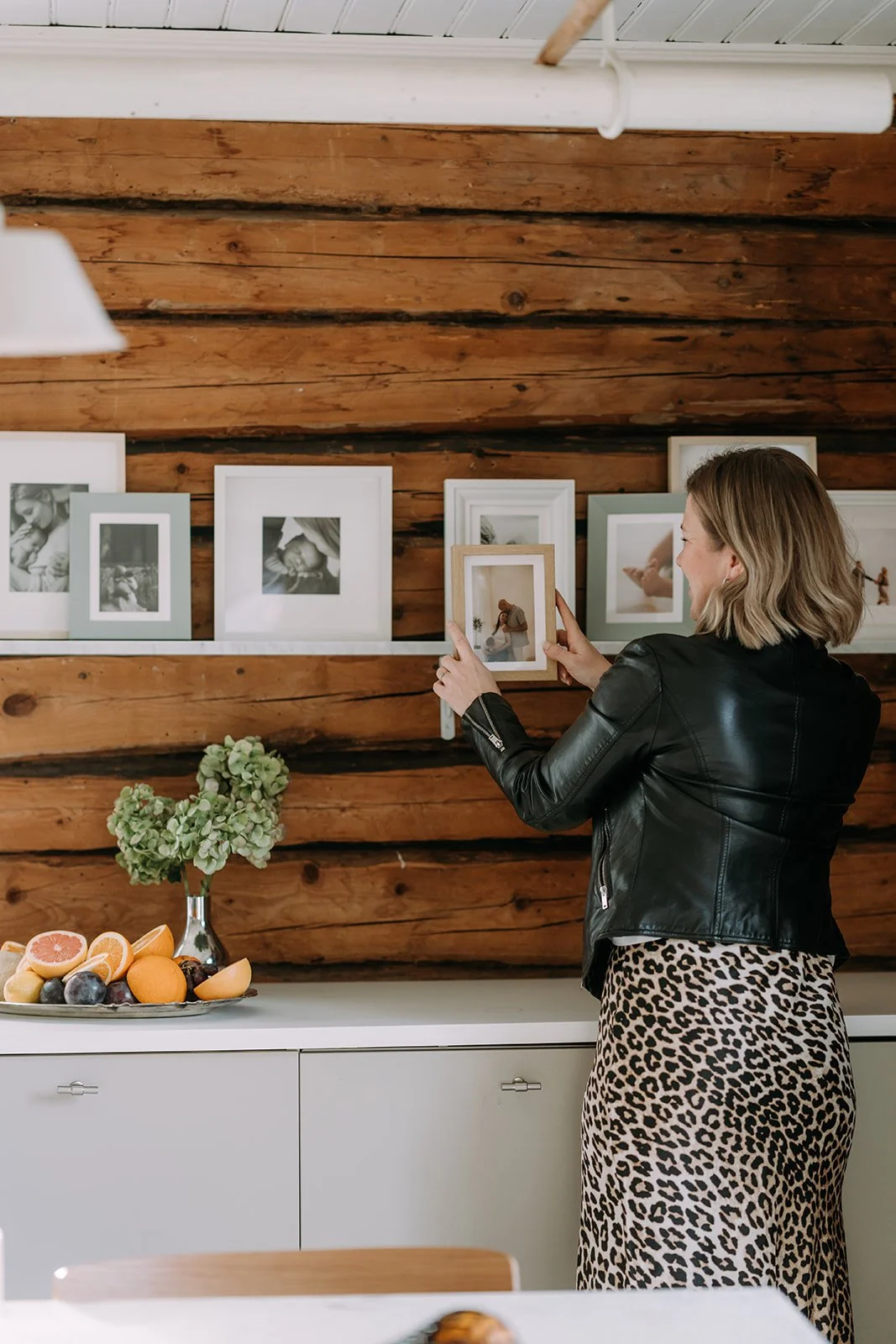 Ammattikuvaaja Heidi Väisänen pitelee käsissään kehyksissä olevia kuvia