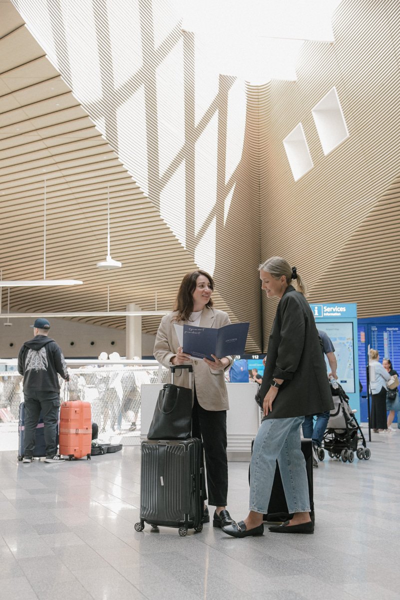 Neam Societyn brändikuvaus lentokentällä. Yrittäjät juttelevat valoisassa lentokentän aulassa.