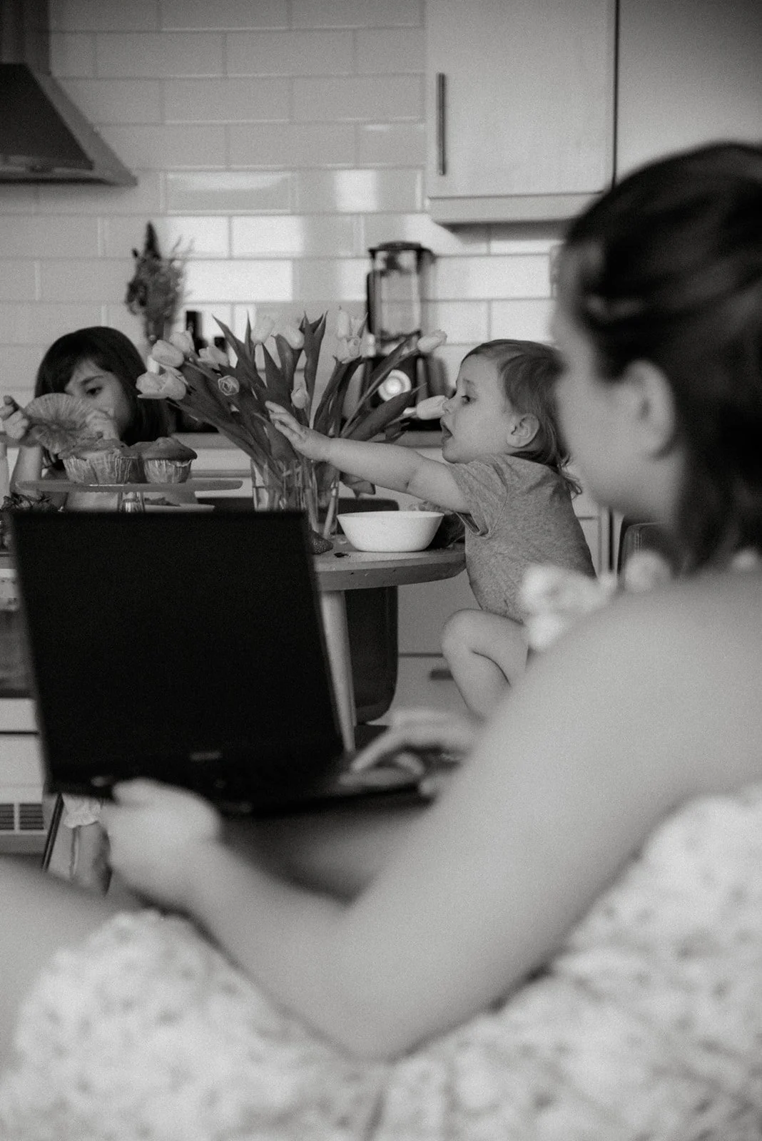 Äiti seuraa vierestä lastensa leikkiä. Perhekuvaus kotona, kuvaaja Heidi Väisänen.