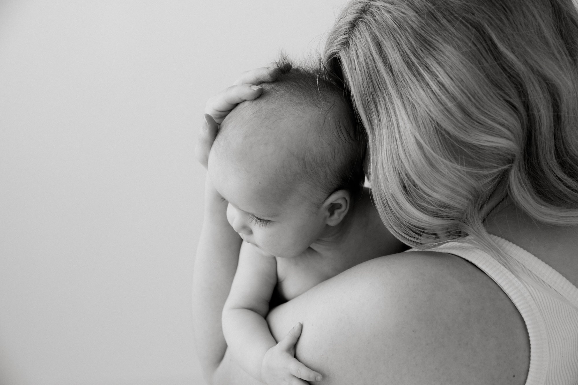 Äiti pitelee hellästi vastasyntynyttä sylissään.