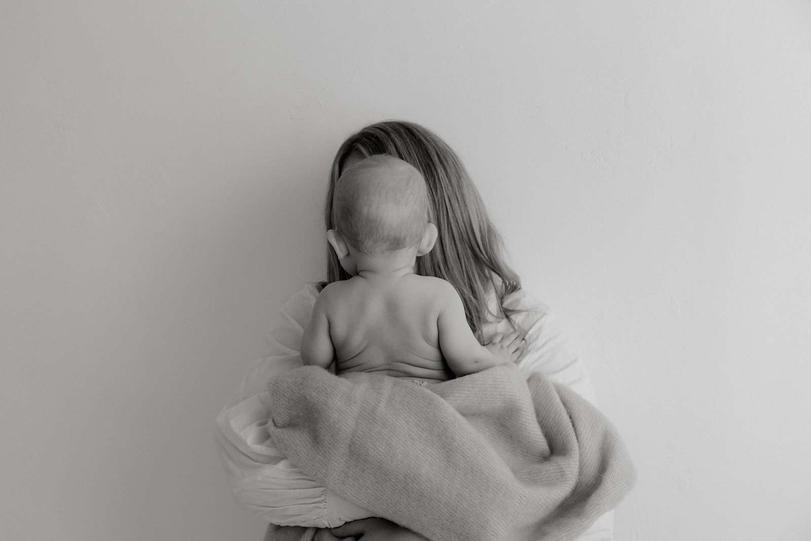 Äidi ja vauva mustavalkokuvassa.