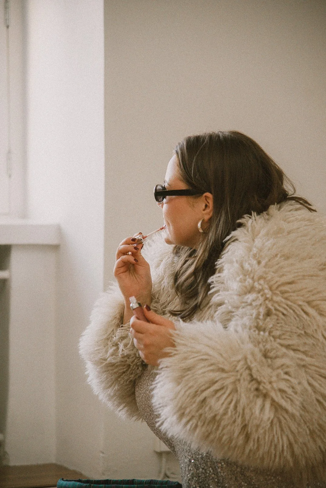 Edlan yrittäjä laittaa huulikiiltonsa. Kuvannut henkilökuvaaja Heidi Väisänen.