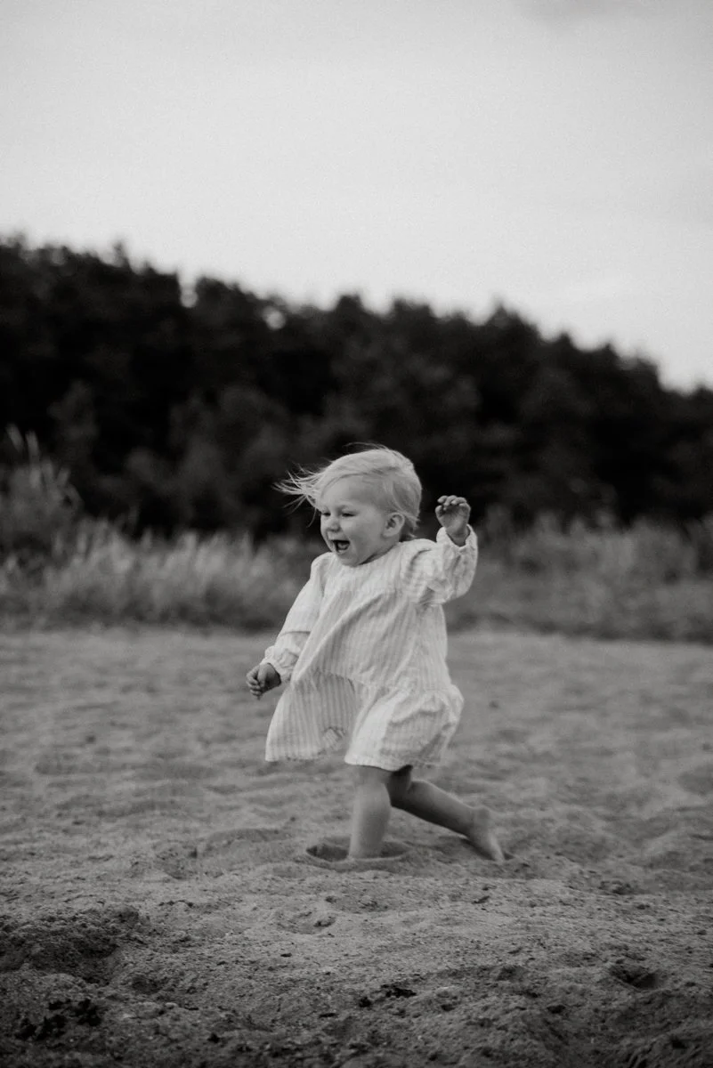 Juokseva pieni lapsi mustavalkokuvassa.