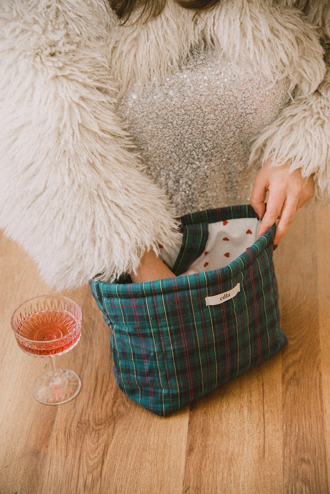 Edlan yrityskuvaus, naisyrittäjä kaivaa brändin pussukkaa lattialla.