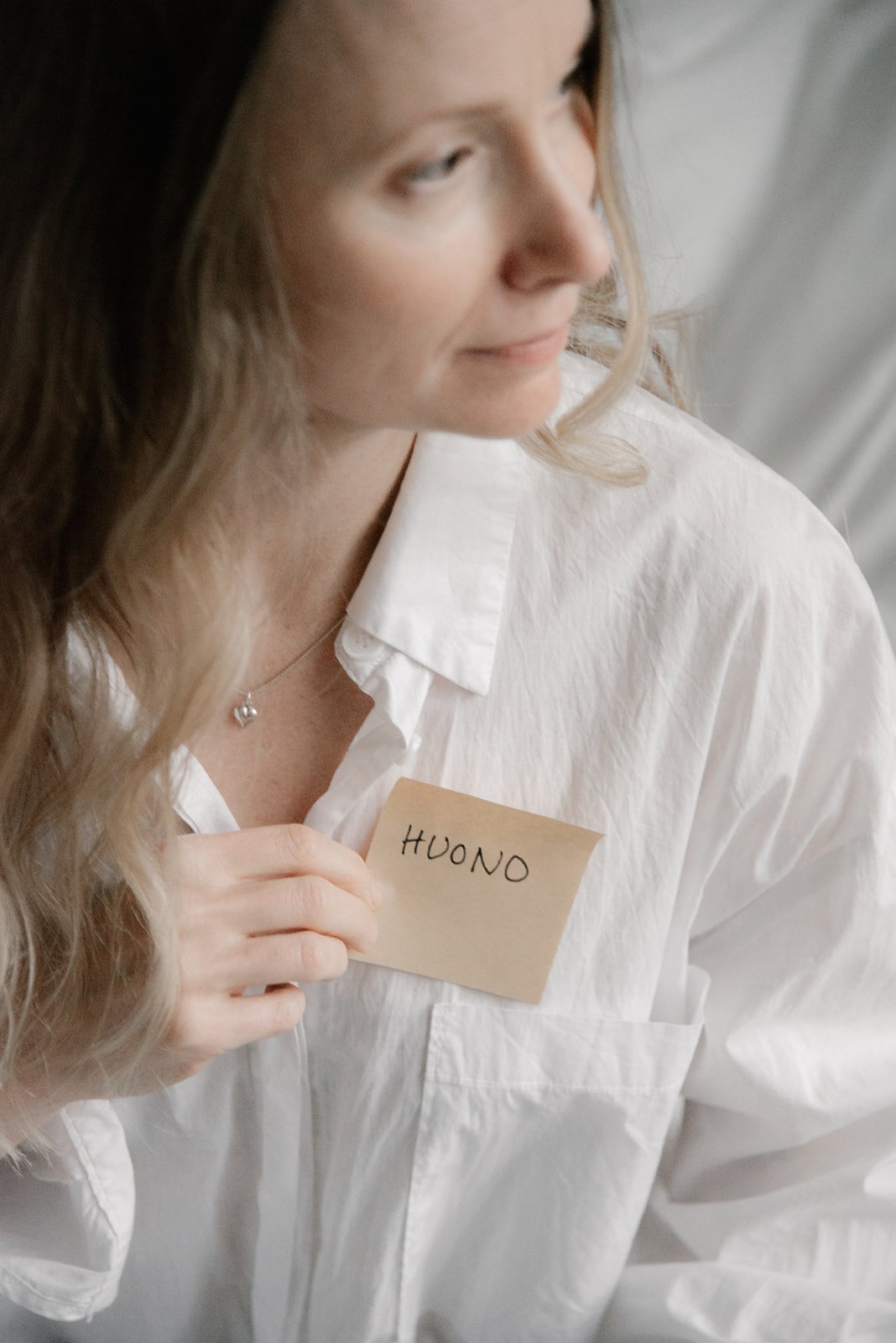 Vaumiin yrittäjä pitelee rinnan päällään muistilappua. 