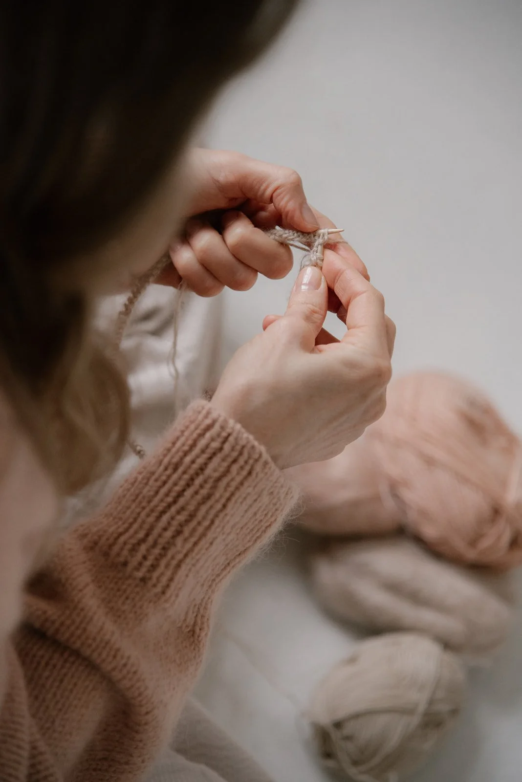 Vaumiin yrityskuvaus, yrittäjä neuloo puikoilla.