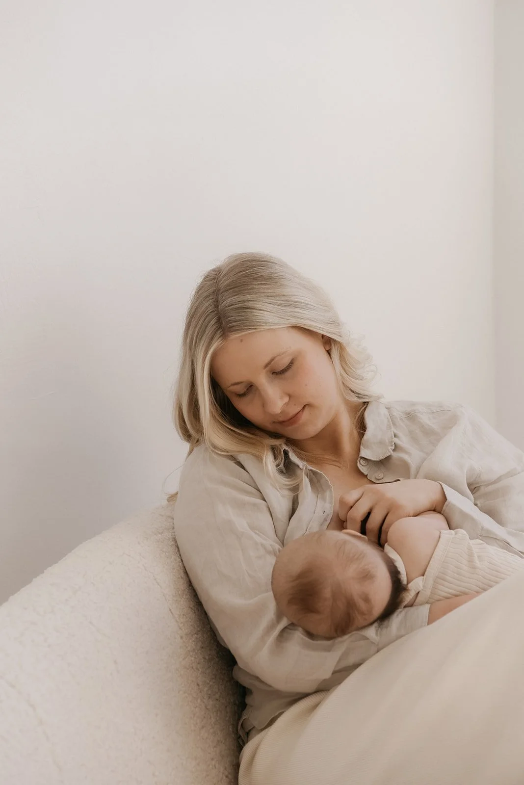 Valokuva vauvaa imettävästä äidistä. Äiti- ja lapsikuvaus Heidi Väisäsen studiolla.