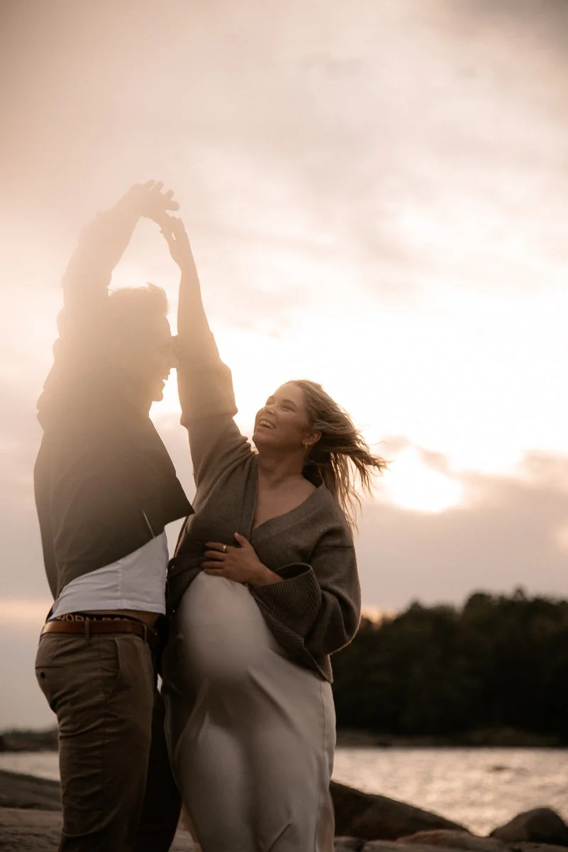 Pariskunta hellissä tunnelmissa auringon laskiessa. Odotusajankuvaus Helsinki.