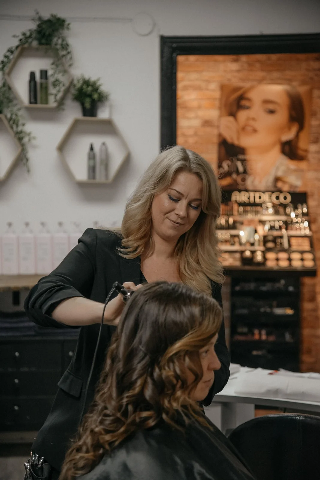 Hykken brändikuvaus. Kampaaja luo kampausta asiakkaalle.