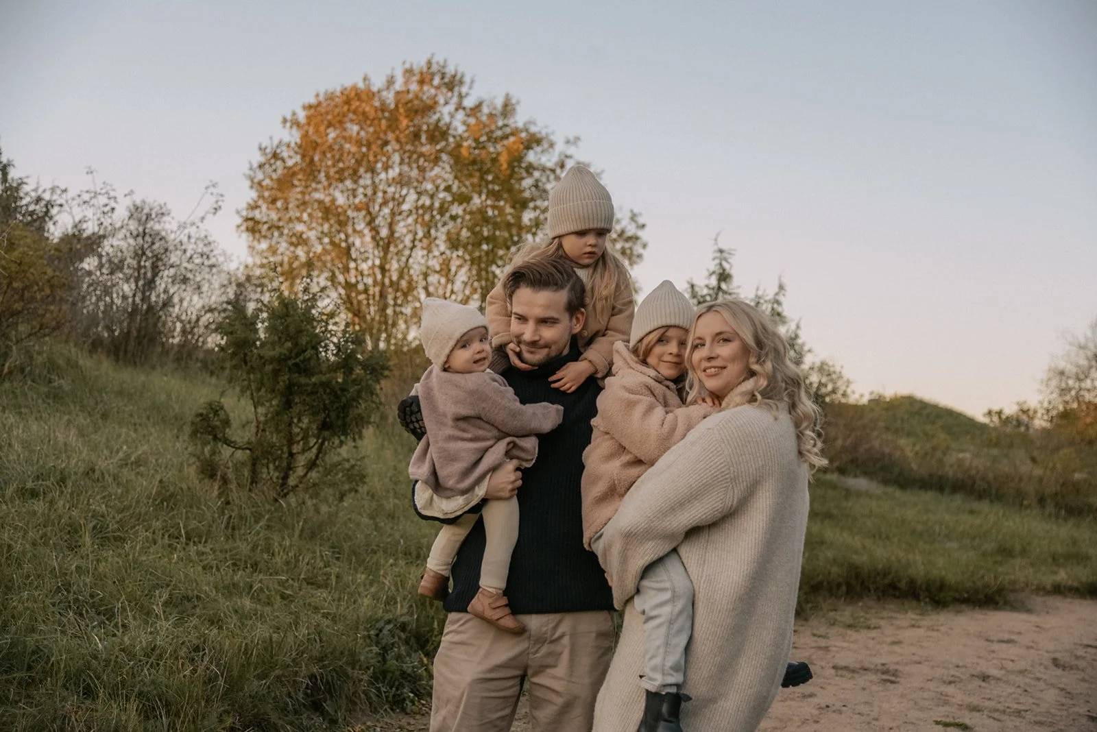 Tunnelmallinen perhekuva luontomaisemassa.