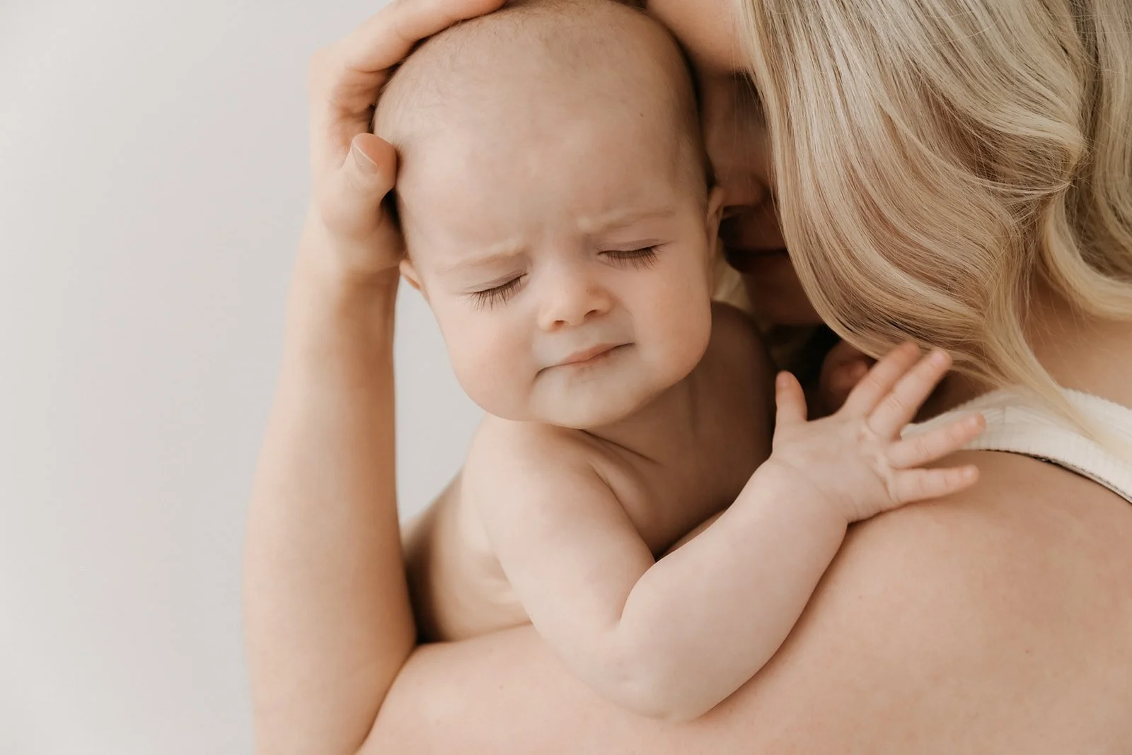 Valoisa ja harmoninen vauvakuv, pieni vauva äidin syleilyssä.