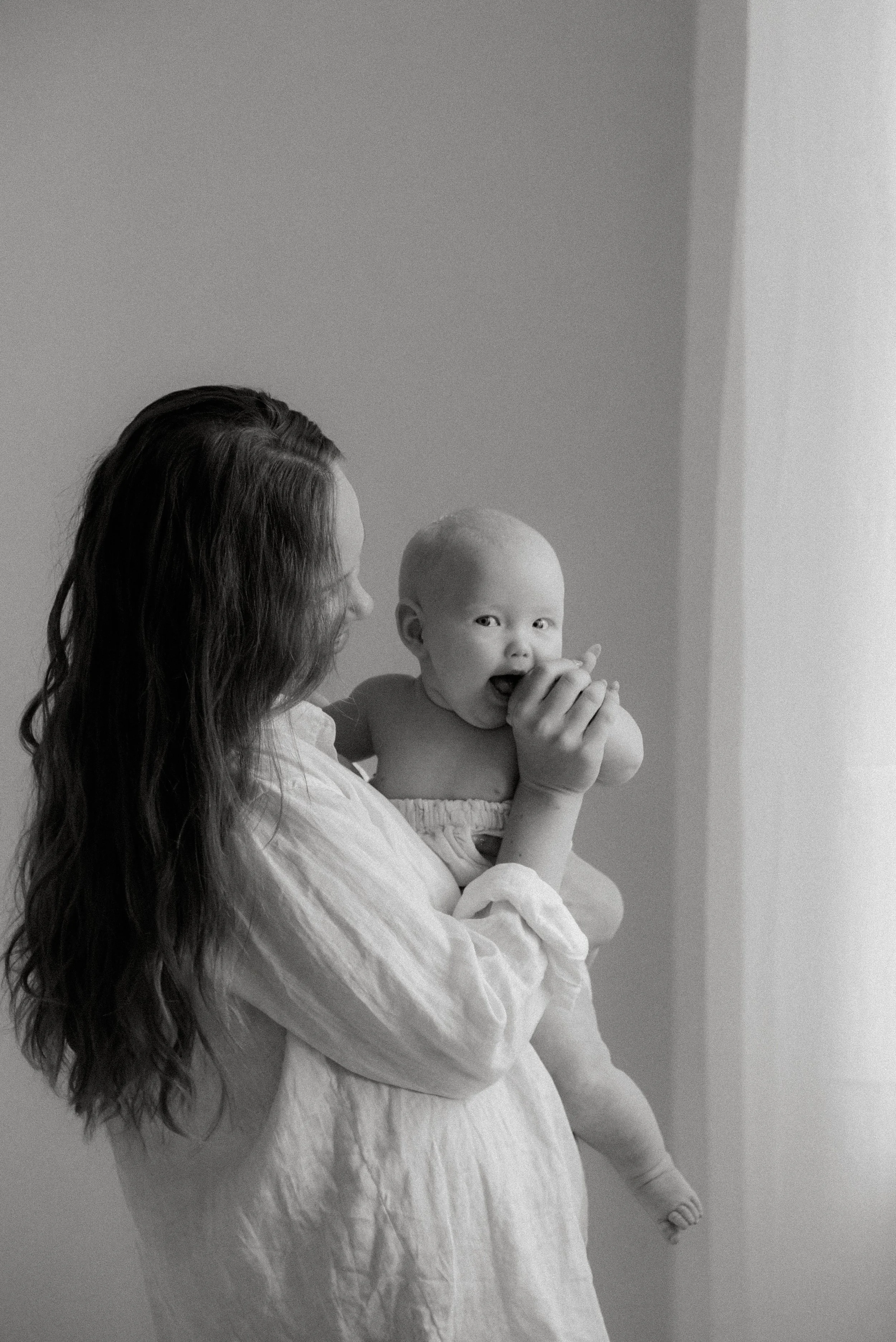 Heidi Väisänen valokuvaa studiollaan äiti- ja lapsikuvia.