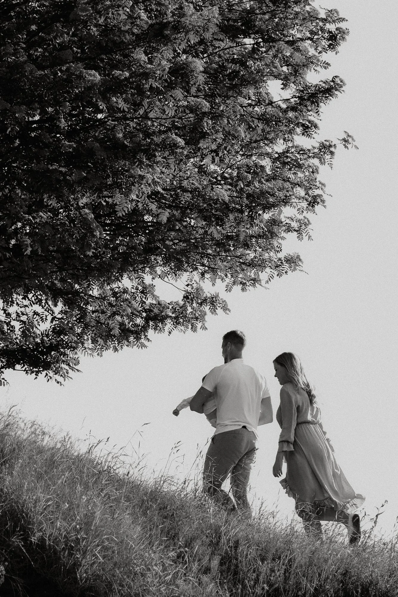 Pariskunta kävelee puun alla mustavalkokuvasas.