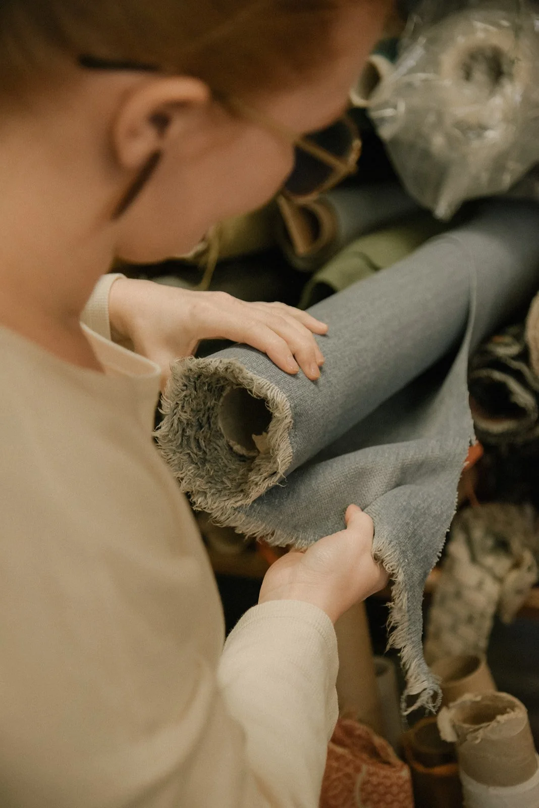 Verhoiluliike Eklundin yrityskuvaus, yrittäjä Ida Eklund kangasrulla käsissään.