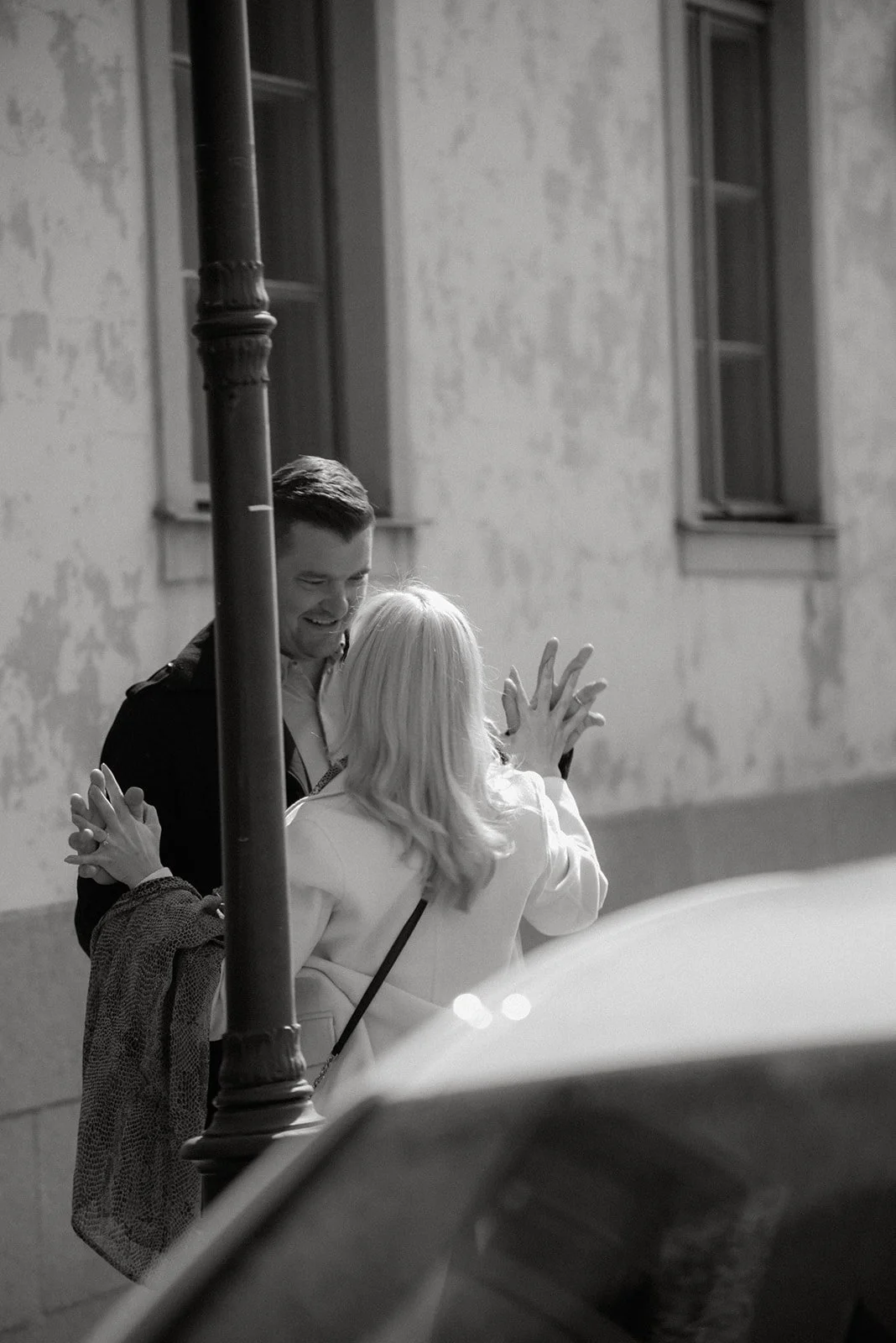 Mustavalkoinen kuva, jossa pariskunta katsoo toisiaan kadulla kädet yhteenliitettyinä. Pariskuntakuvaus Helsinki.