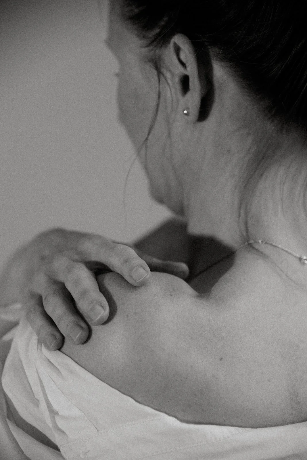 Mustavalkoisessa kuvassa nainen halaa itseään.