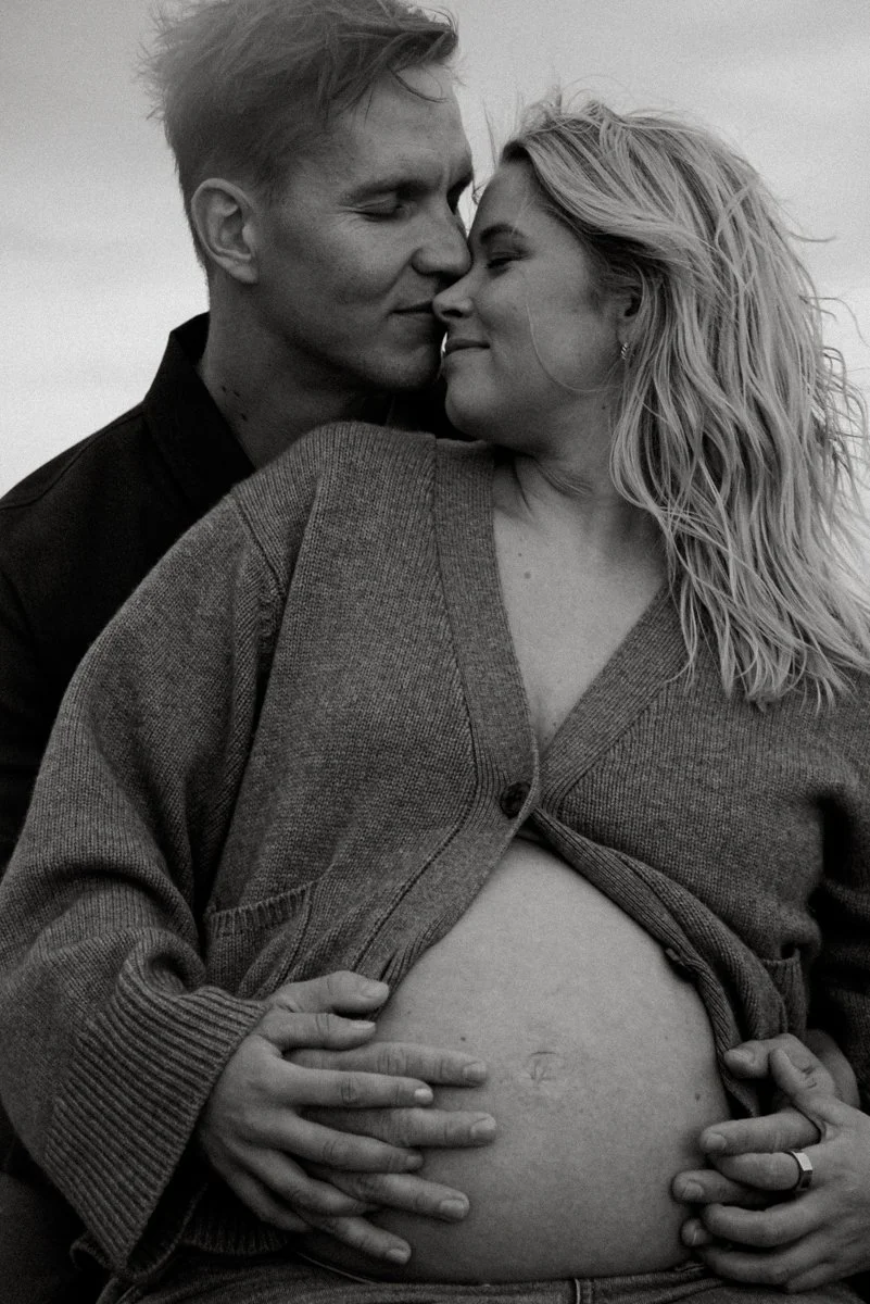 Pariskunnan hellä syleily odotuskuvassa.