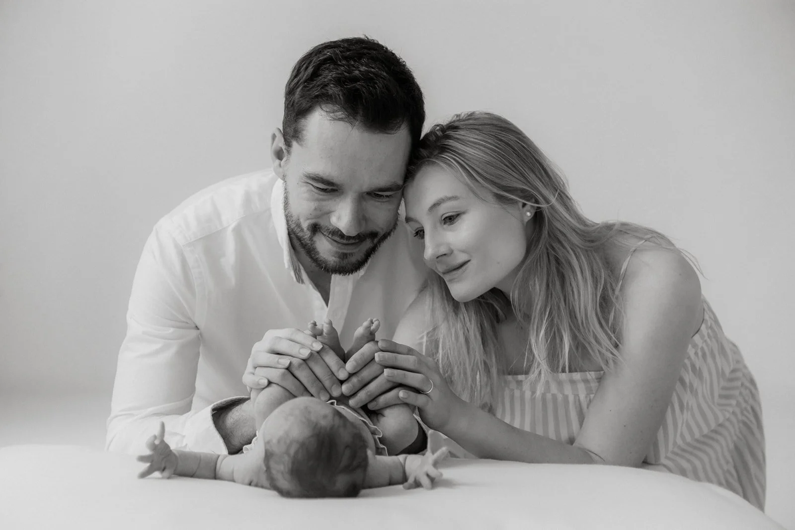 Vanhemmat vauvan kanssa kuvauksessa valokuvausstudiolla.