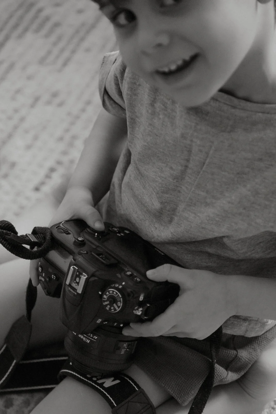 Heidi Väisäsen kuvaama perhekuva. Lapsi pitelee kameraa kädessään ja hymyilee