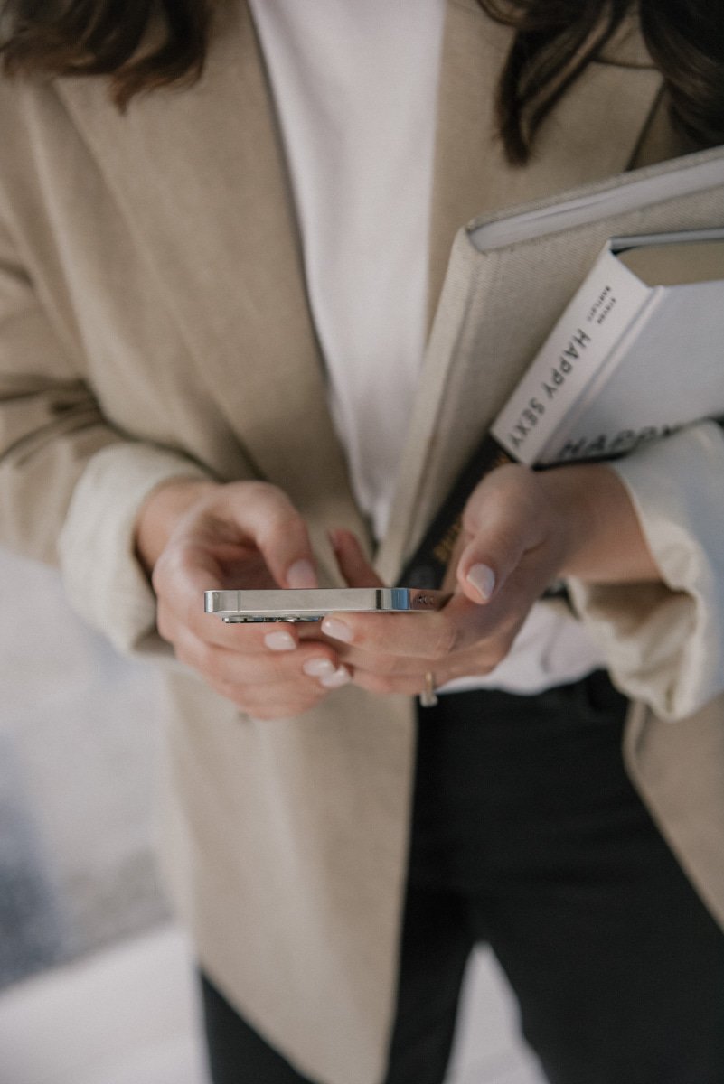 Neam Societyn yrittäjä näpyttelee kännykkää. Kuvannut yrityskuvaaja Heidi Väisänen.