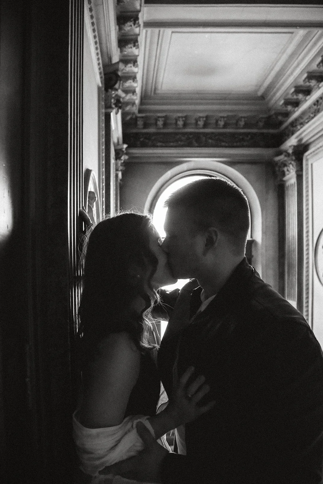 Mies ja nainen suutelevat koristeellisessa rappukäytävässä. Pariskuntakuvaus Helsinki.