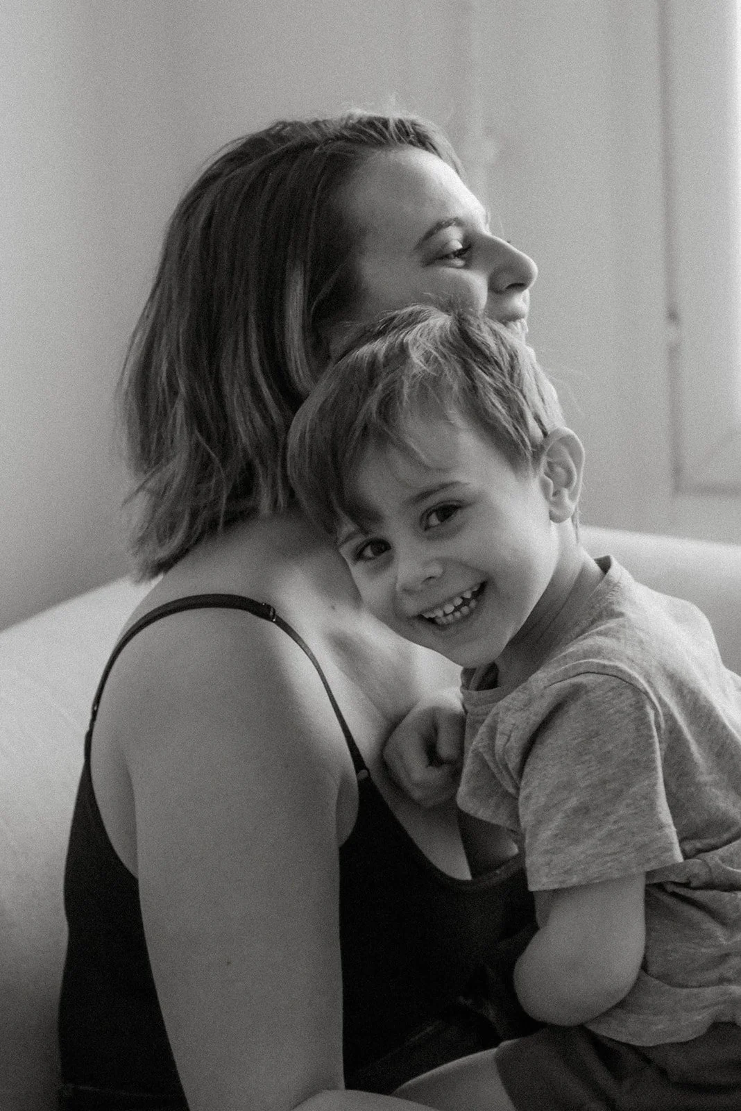 Mustavalkoinen kuva äidistä ja lapsesta. Perhekuvaus kotioloissa.