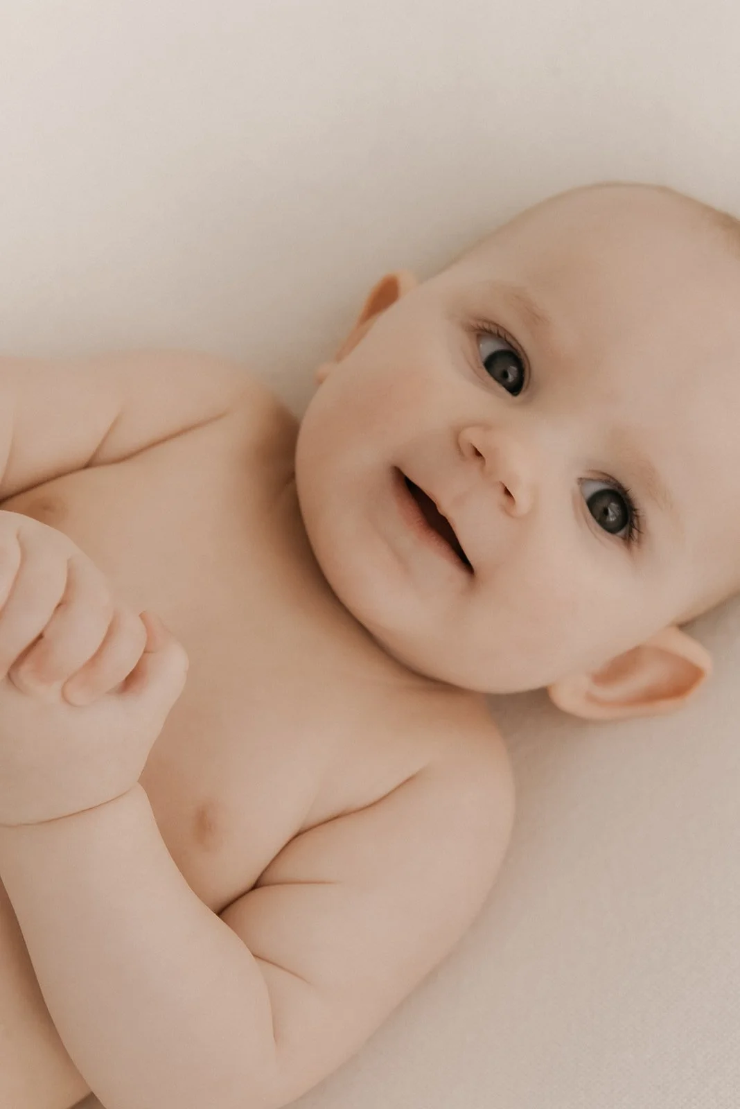 Vaaleassa ja harmonisessa kuvassa pieni vauva. Vauvakuvaus Heidi Väisänen studiolla.