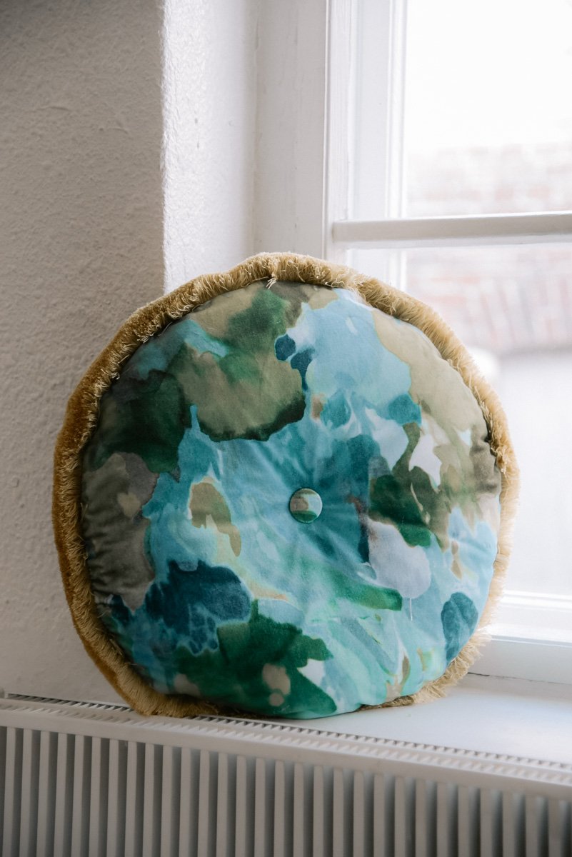 Värikäs verhoiltu tyyny ikkunalaudalla. Tuotekuva Verhoomo Vanhan Viehätykselle.